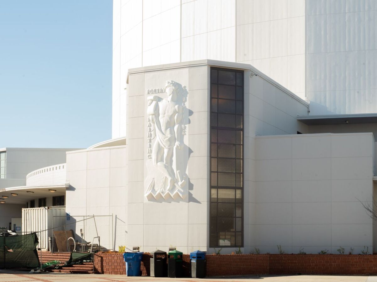 Outside of gleaming white building with bas relief of bare-chested Greek-looking figure