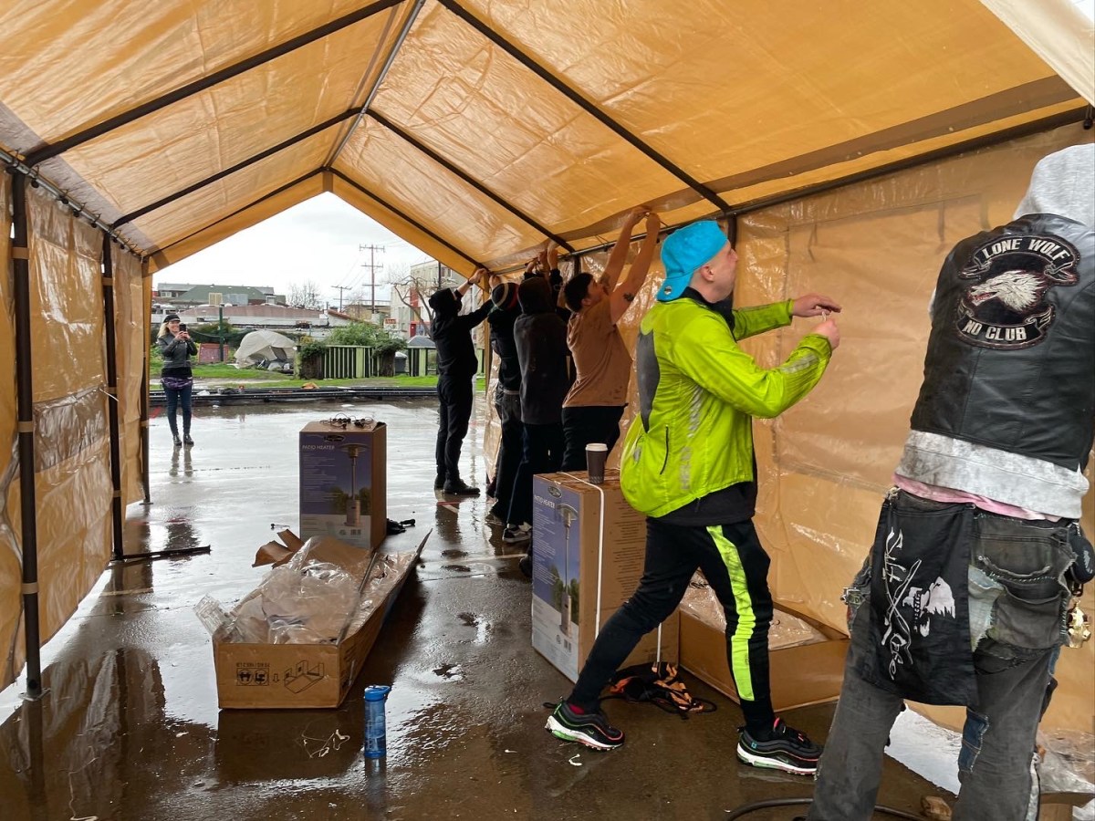 Activists assemble a canvas tent.