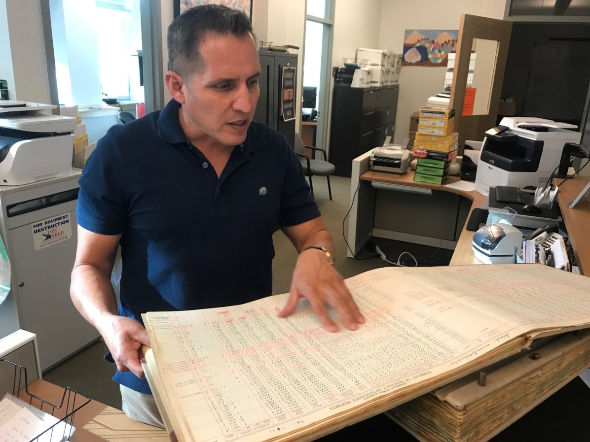 BUSD Admissions Manager Francisco Martinez pores over district enrollment records from the 1930s. Photo: Natalie Orenstein