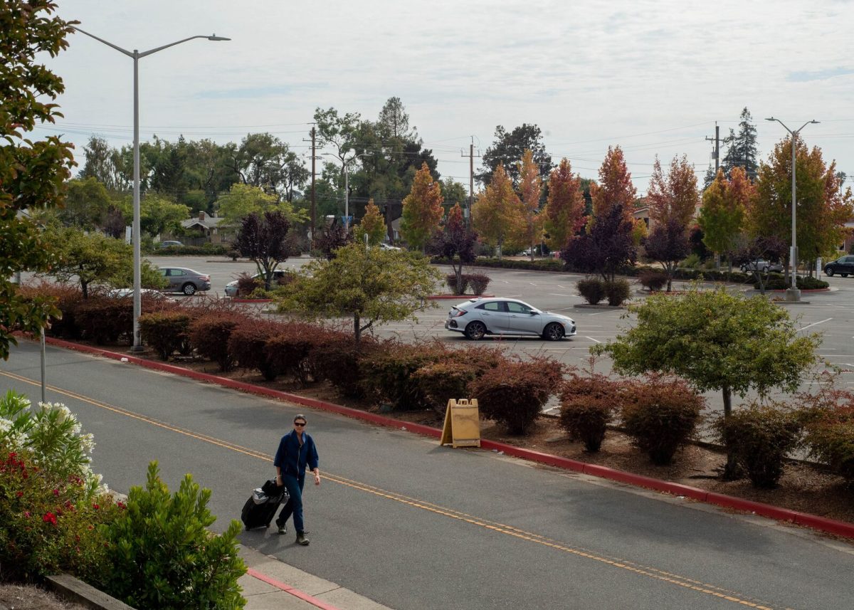 A person walks through the North Berkeley BART station parking lot