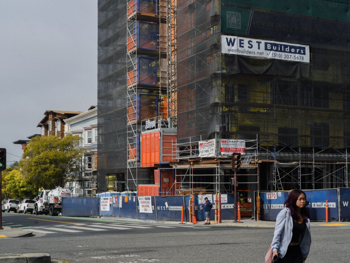 Pedestrians walk past a construction site in downtown Berkeley